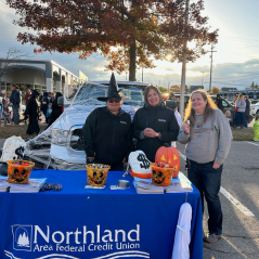 Northland Team members behind a Northland table at the trunk or treat.