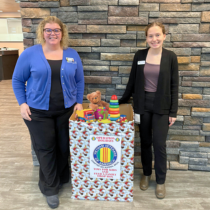 Here is Northland's Kelly and Maddy standing next to the Toy Drive Donation Box for 2024 Holiday Operation Toy Donations