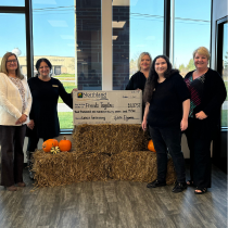 Here is a group of Northland employees and Friends Together representatives posing for a picture holding a large check for cancer fundraising.