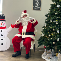 Here is a photo of Santa sitting by a tree at the Evart Meet and Greet Santa event.