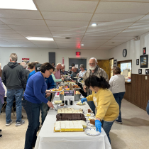 Here is a photo of Iosco County community members making their plates at the Isoco County Veterans Luncheon. 